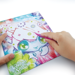 Dziecko używa różowego rysika, aby dodać kolorowe klejnoty do "Albumu do scrapbookingu z Marinią i dodatkami" z Mariną. Ponumerowane miejsca prowadzą do ich umieszczenia, dzięki czemu idealnie nadaje się do scrapbookingu lub kolekcjonowania dodatków.